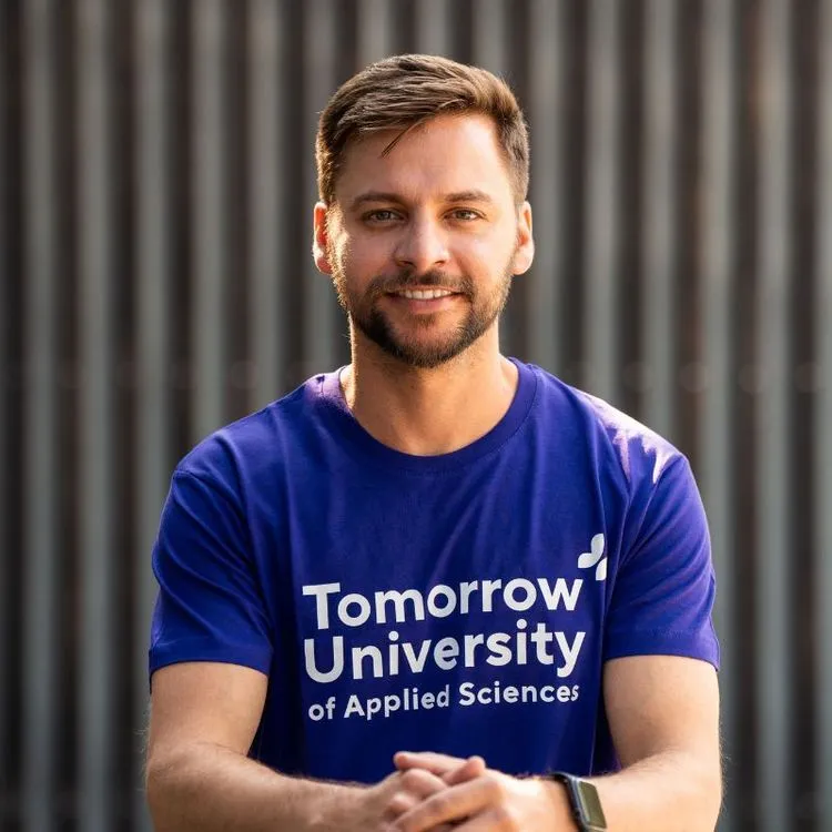 A portrait of Prof. Dr. Jonathan Costa wearing a purple Tomorrow University T-Shirt.