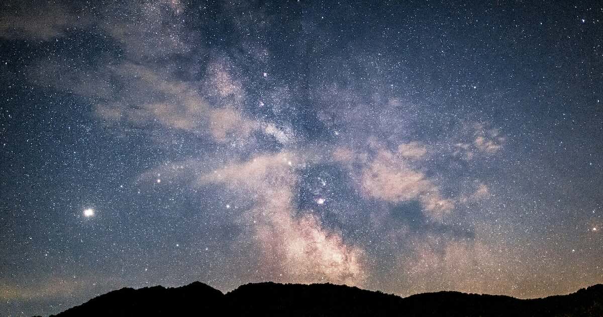 Starry night sky with the Milky Way glowing above mountain silhouettes, symbolizing clarity, direction, and purpose - reflecting the theme of discovering your personal mission statement.