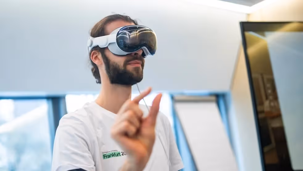 Person wearing a virtual reality headset and interacting with a digital interface, exploring immersive technology in a modern learning or innovation space.
