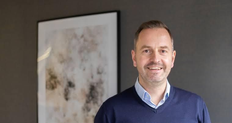 Bernhard Niesner, Busuu co-founder and Tomorrow University board member, smiling in a blue sweater.