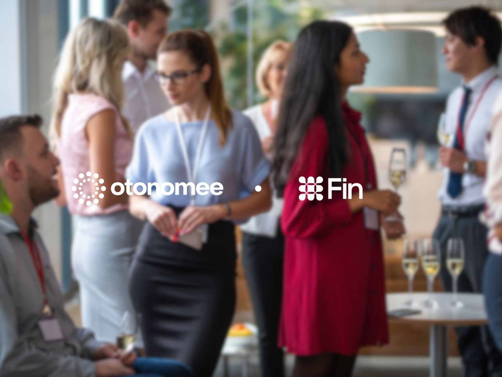 People networking at a professional event with wine glasses and name tags in a modern indoor setting.