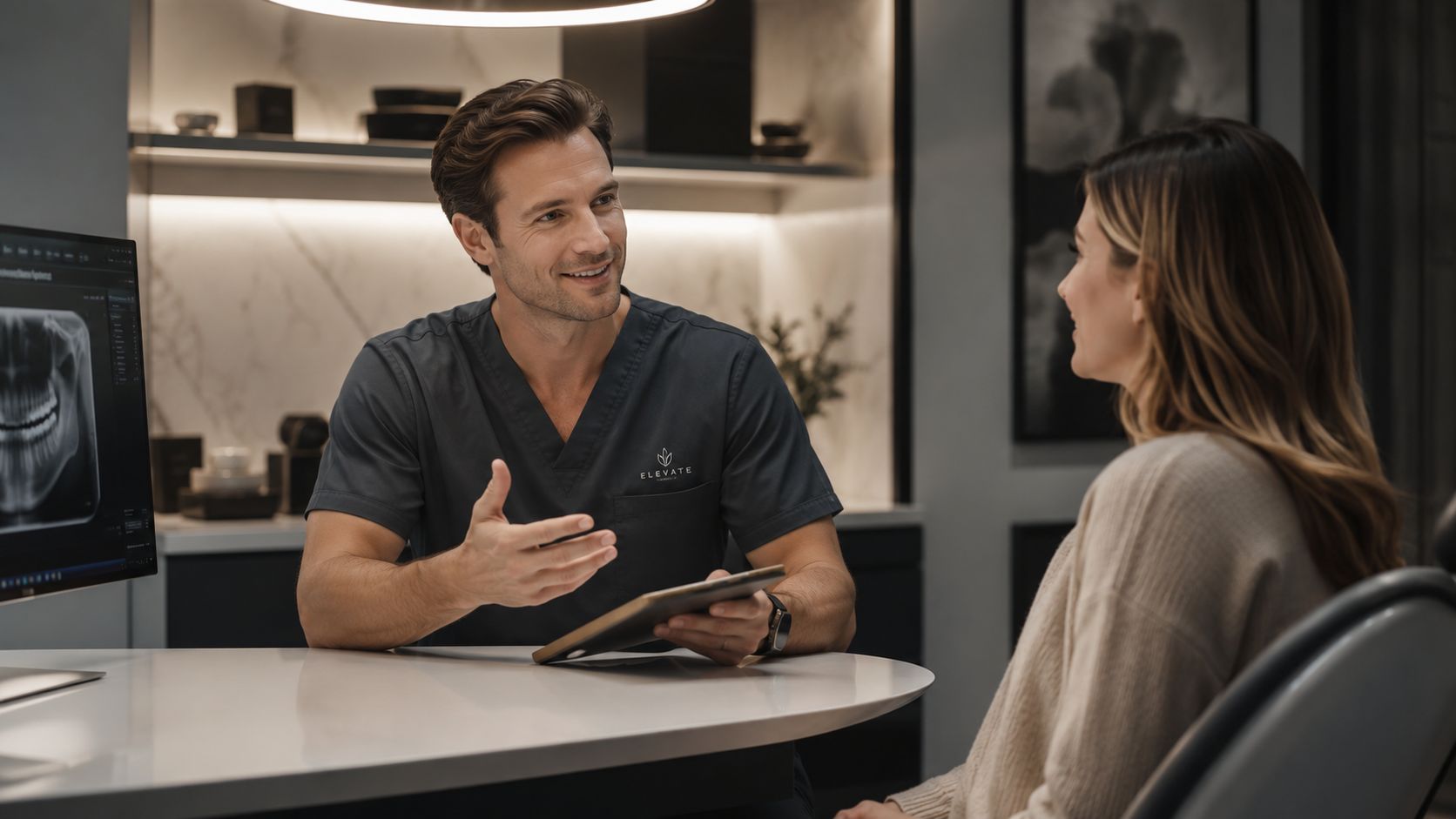 A friendly male dentist explains a treatment plan to a patient in a modern dental office.