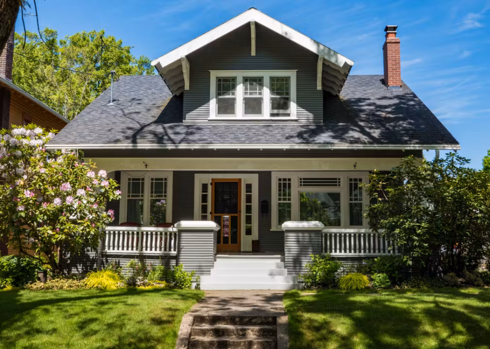 Charming craftsman-style house with a front porch, gabled roof, and landscaped yard.