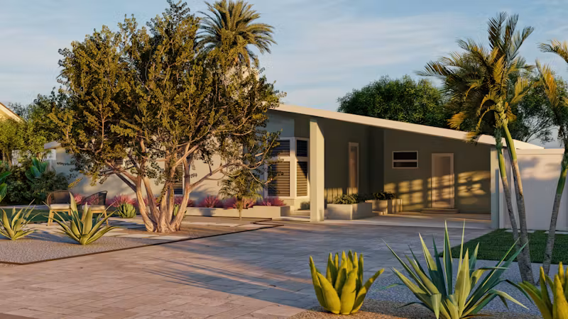 A modern single-story home with desert landscaping, palm trees, and a paved driveway.