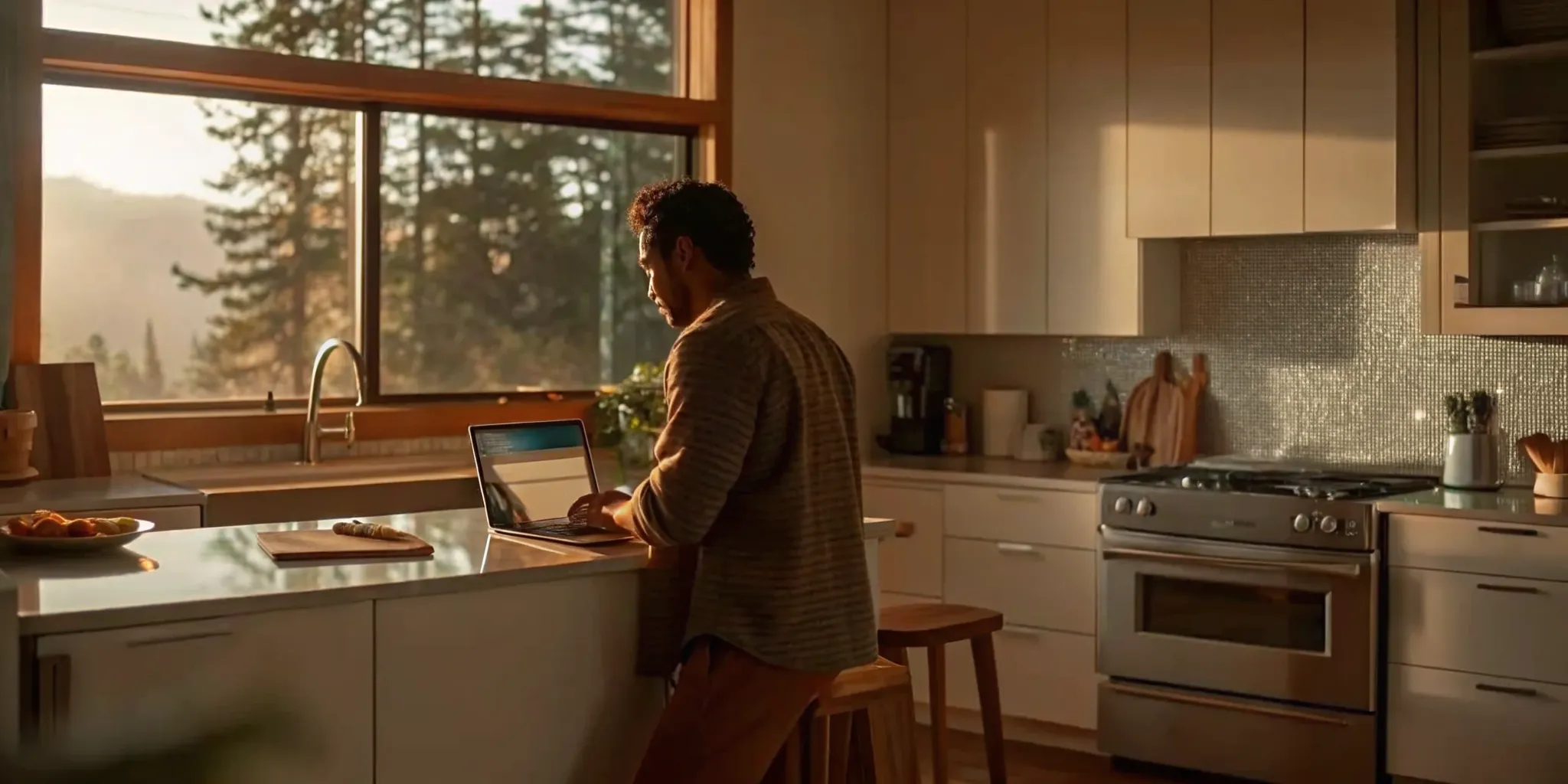 Man in a modern kitchen researching how to hire a kitchen renovation company.