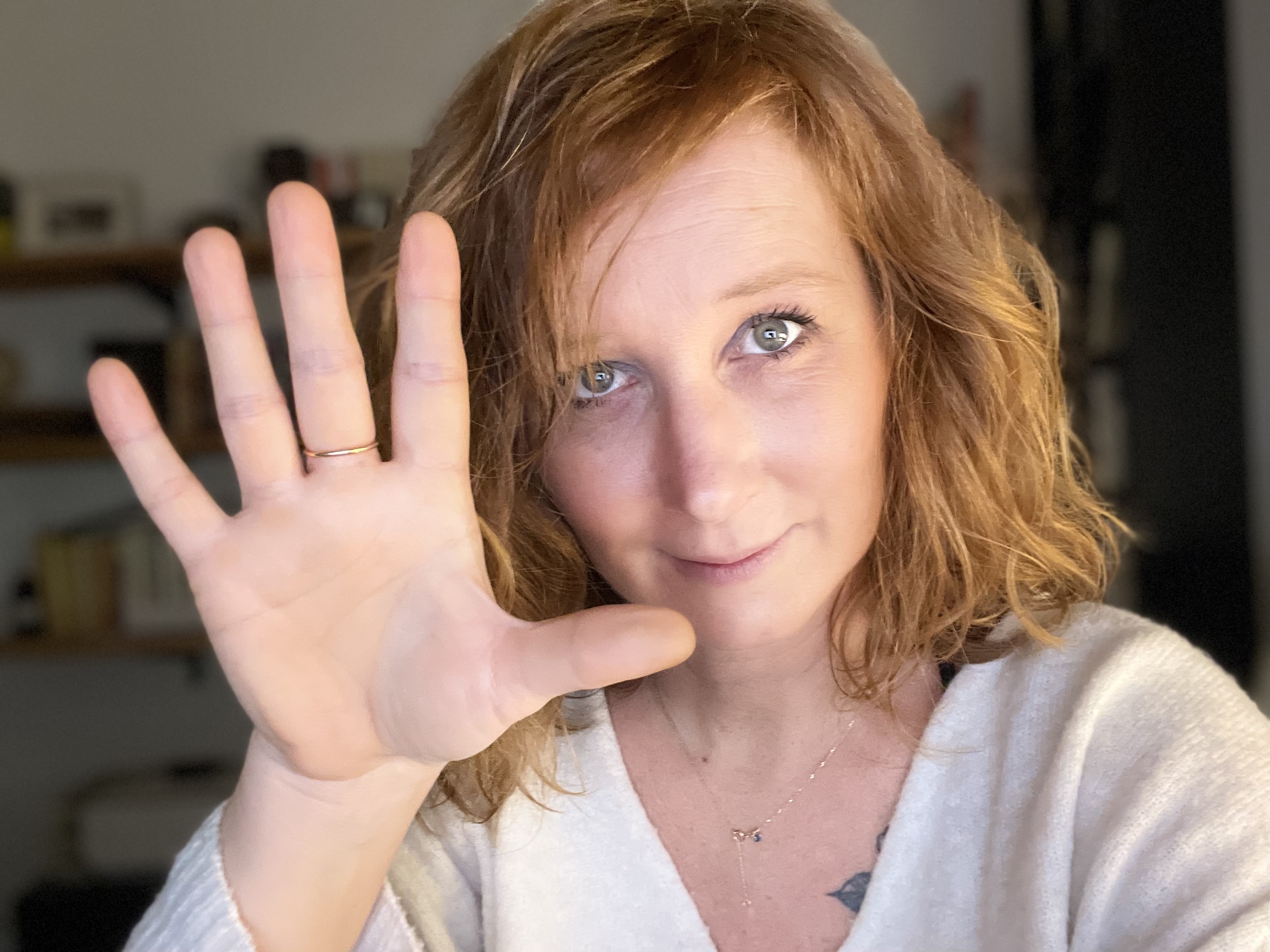 femme rousse avec main devant elle doigts écartés