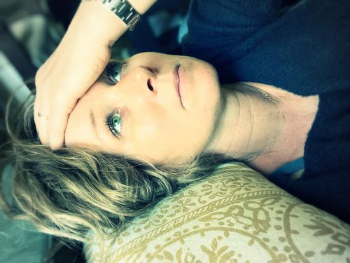 Femme assise en bas d’un escalier se tenant le menton de la main droite