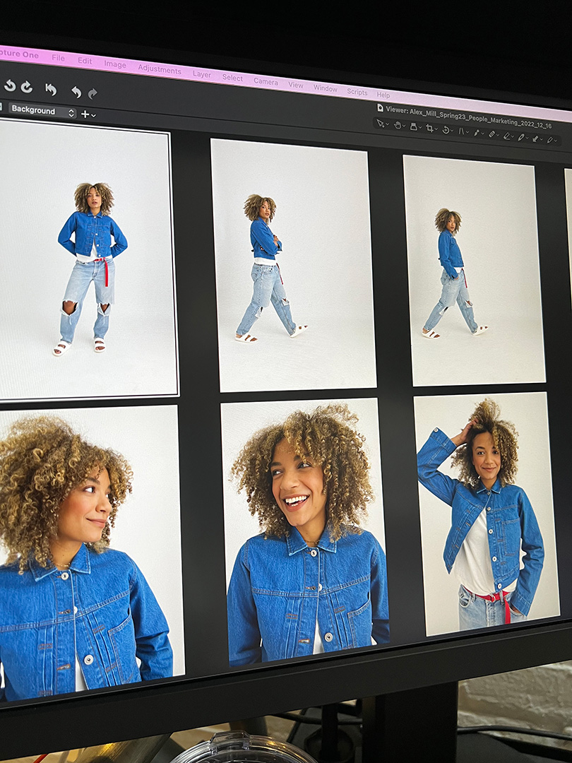 A computer screen displaying a Capture One editing session featuring a photoshoot with Natalie Wright for Alex Mill. The images show her wearing a blue denim jacket, a white t-shirt, and light-wash ripped jeans with a red belt. The shots capture a mix of full-body and close-up portraits with a neutral white background.