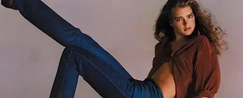 model wearing denim jeans with one leg up