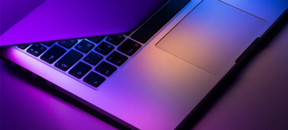 laptop keyboard illuminated by purple and blue light representing digital marketing tips