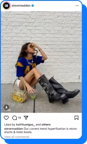 woman sitting on pavement wearing black moto boots with buckle