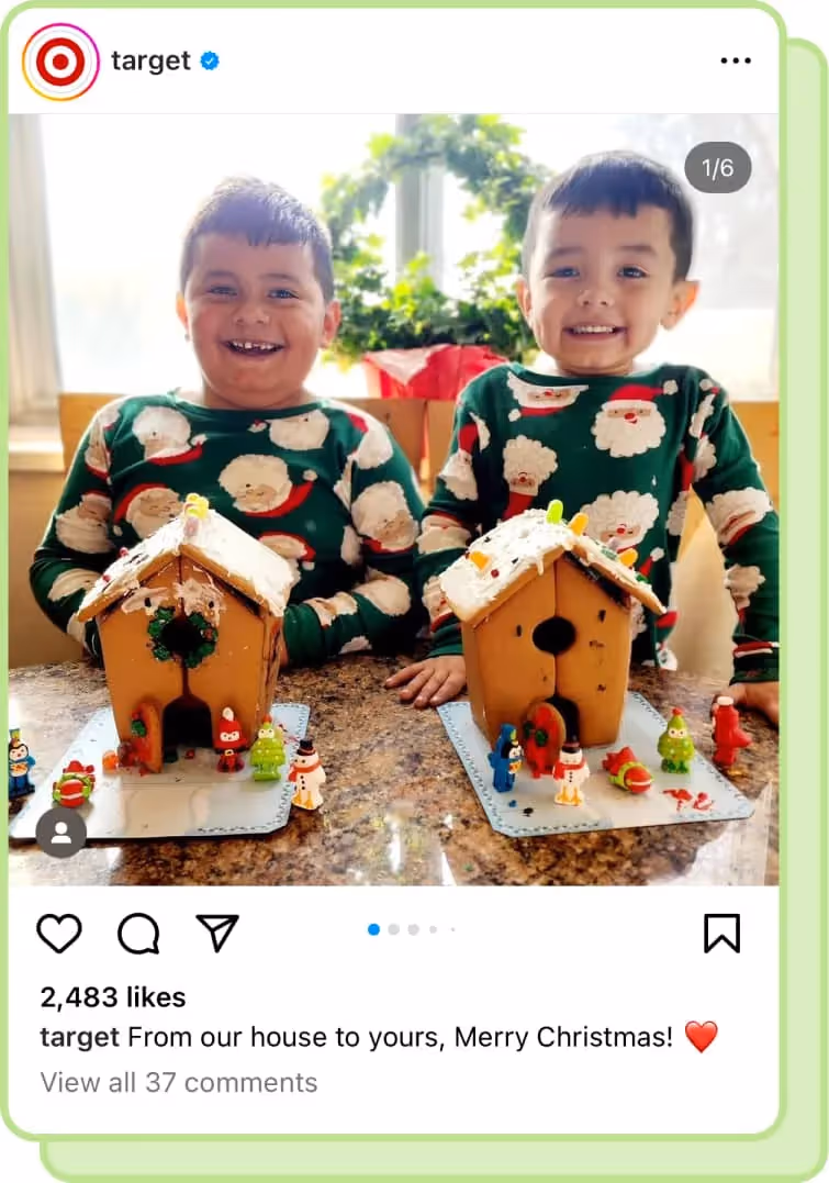 two young boys wear christmas pajamas and stand behind gingerbread houses
