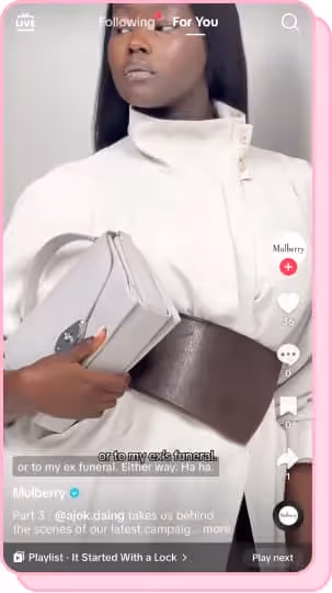 woman wearing white dress and brown leather belt posing with grey mulberry purse