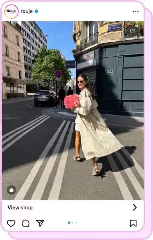 bride in trenchcoat walking in street with bouquet