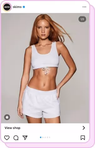 red hair wearing white skims sports bra and white shorts