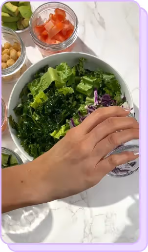 hand adding red cabbage to salad 