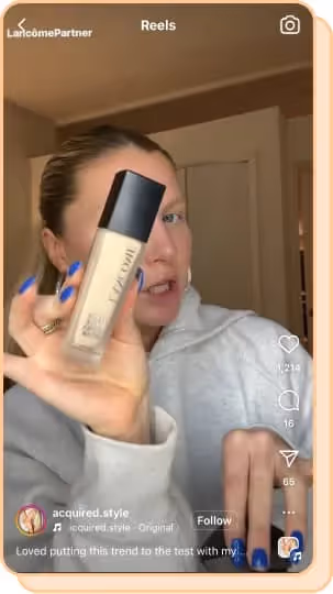 blonde woman holding up lancome foundation 