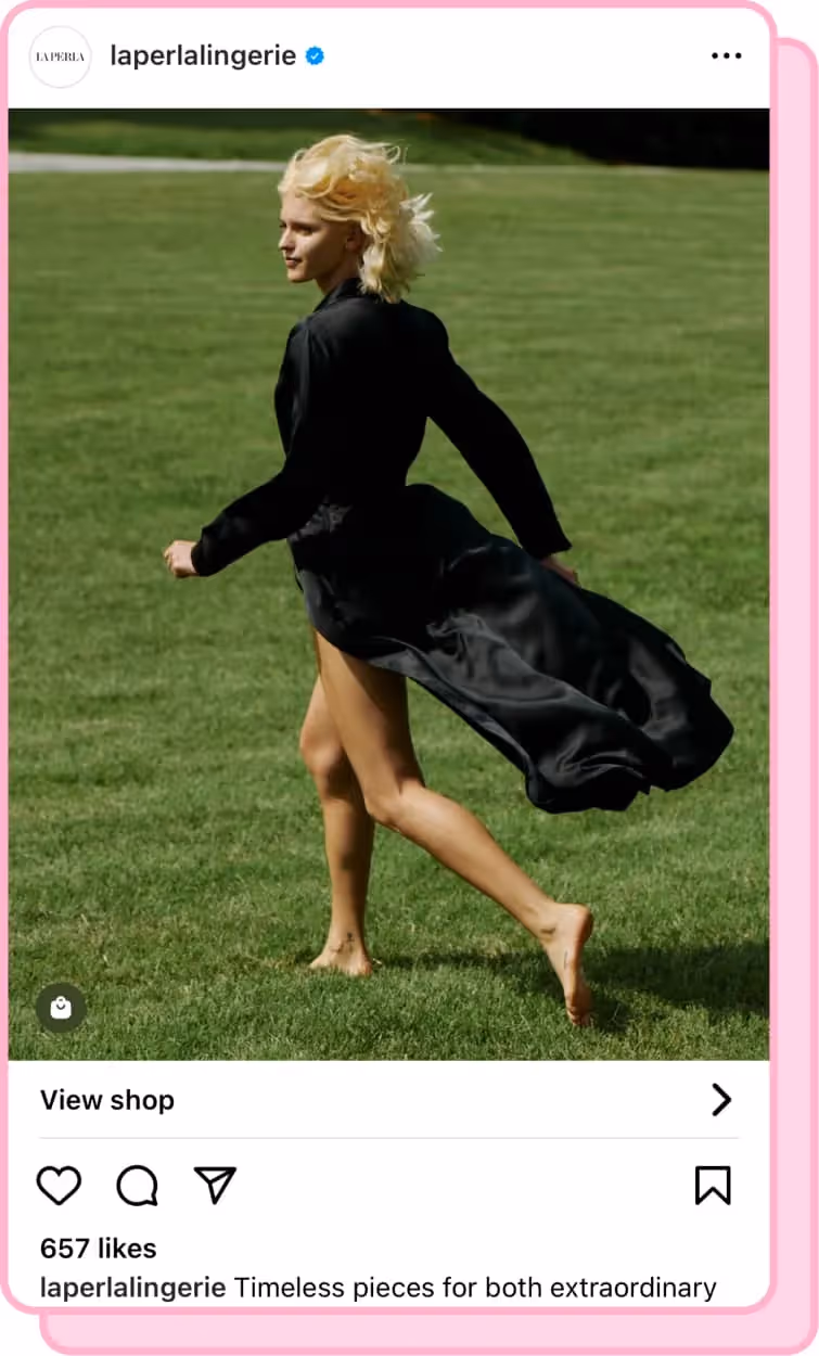blonde girl running through grass wearing black silk robe that's blowing in the wind
