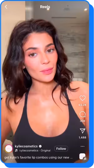 A woman with wavy dark hair in a black top posing in a well-lit bathroom setting