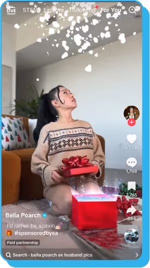 TikTok video of a creator sitting on the floor, opening a glowing red gift box with sparkles above