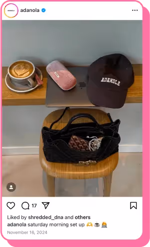 Flat lay of coffee, MacBook, Adanola cap and purse on a stool in cozy cafe