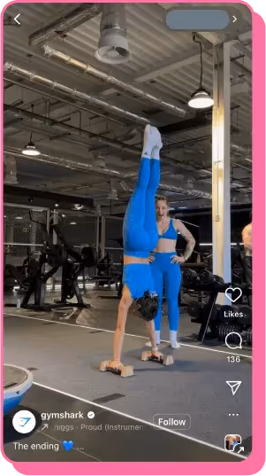 Woman performs handstand push-up on blocks in gym while trainer watches