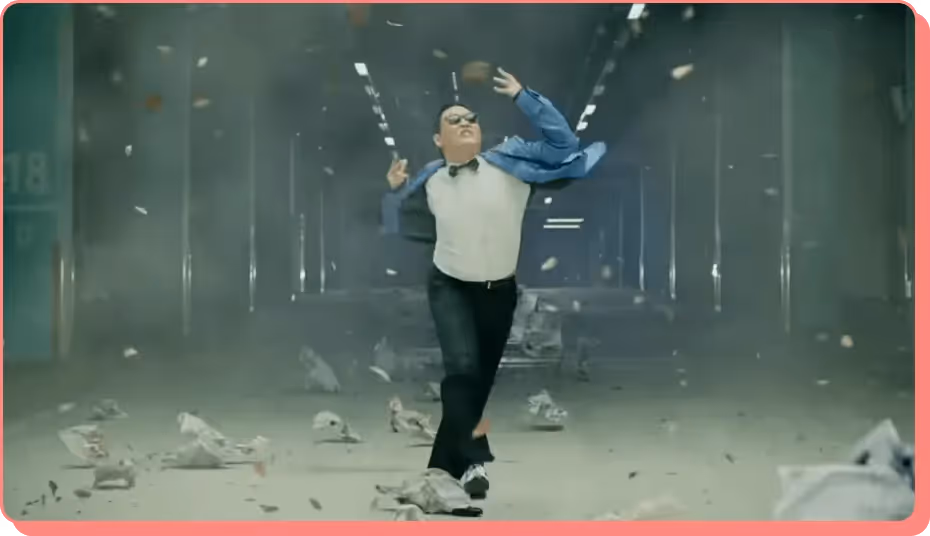 PSY in Gangnam Style running through debris, from a viral most viewed YouTube hit.