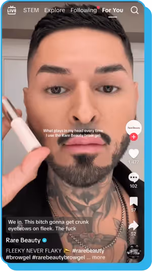 Tattooed influencer applying brow gel in a TikTok influencer marketing post for Rare Beauty.