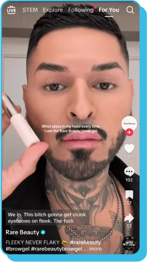  Tattooed influencer applying brow gel in a TikTok influencer marketing post for Rare Beauty.