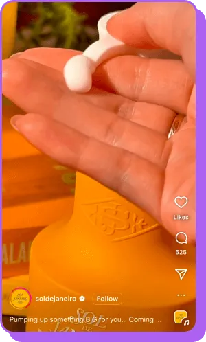 Hand dispensing cream from Sol de Janeiro bottle in vibrant orange packaging