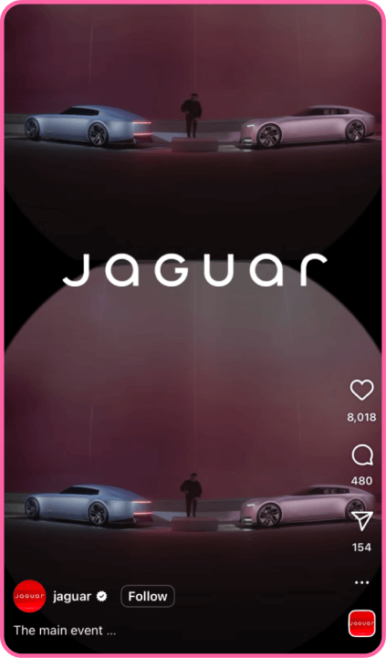 Jaguar showcases two sleek concept cars on a dark stage with ambient lighting and a person between them.