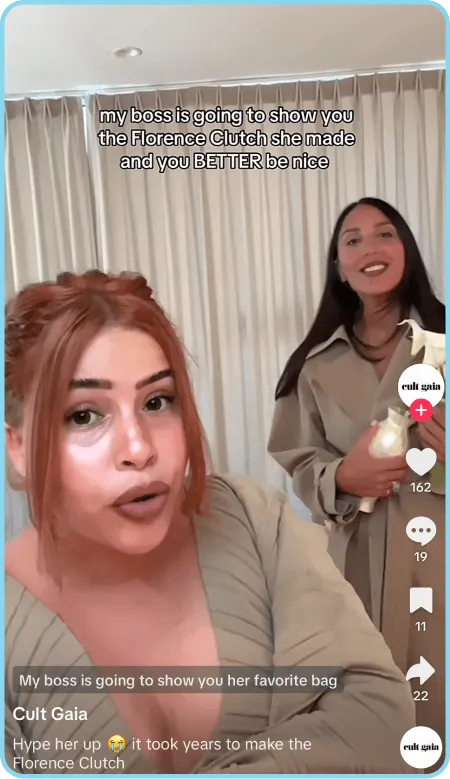 Two women showcasing Cult Gaia Florence Clutch in a TikTok video.