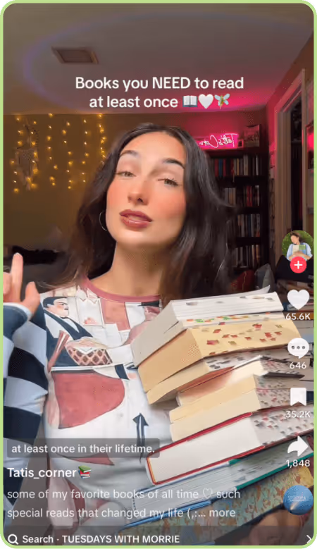TikTok creator recommending books to read at least once while holding a stack.