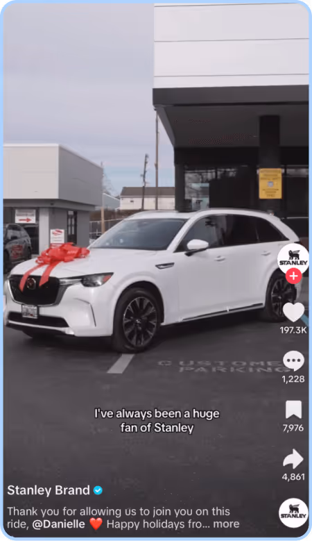 White SUV with red bow in dealership lot featured in Stanley Brand TikTok.