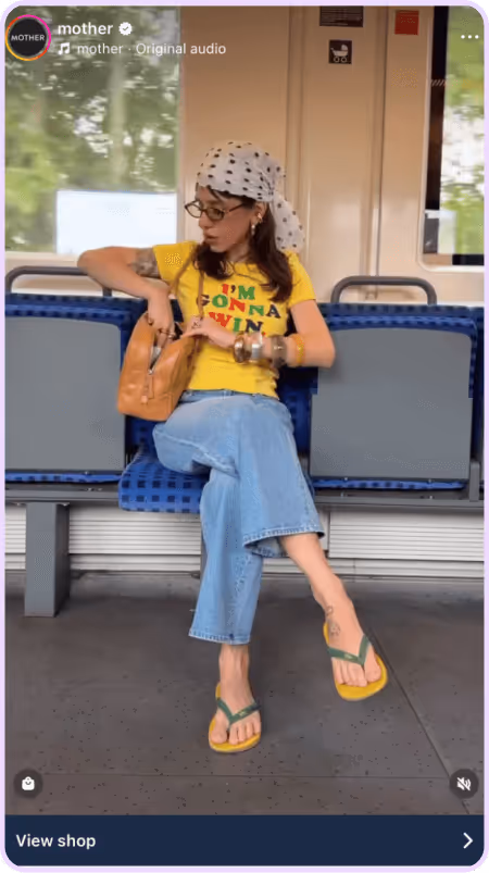 Woman in yellow graphic tee and jeans sitting on train seat with flip-flops and headscarf