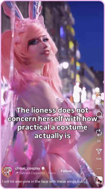 Cosplayer in a pink wig and fantasy costume posing on a city street at night.