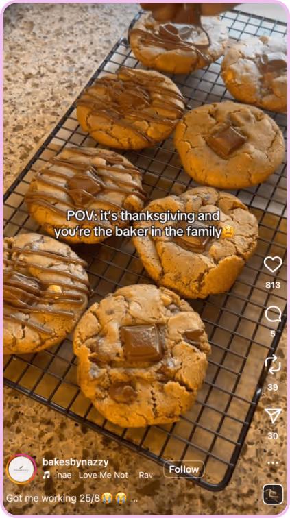 Freshly baked cookies with melted chocolate cooling on a wire rack in a kitchen.