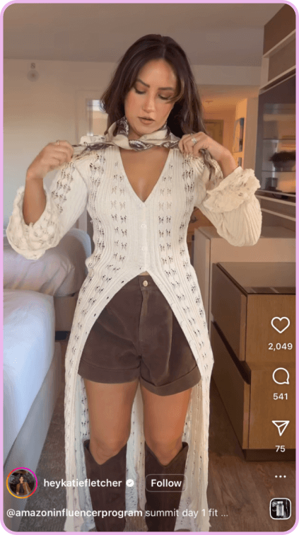 Woman adjusting scarf while wearing a white crochet top, brown shorts, and knee-high boots.