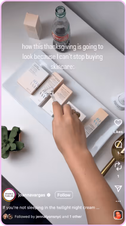 Hand reaching for stacked skincare boxes on a tray with a glass bottle and decor nearby.