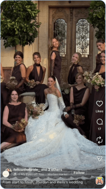 Bride in white gown posing with bridesmaids in dark dresses outside venue