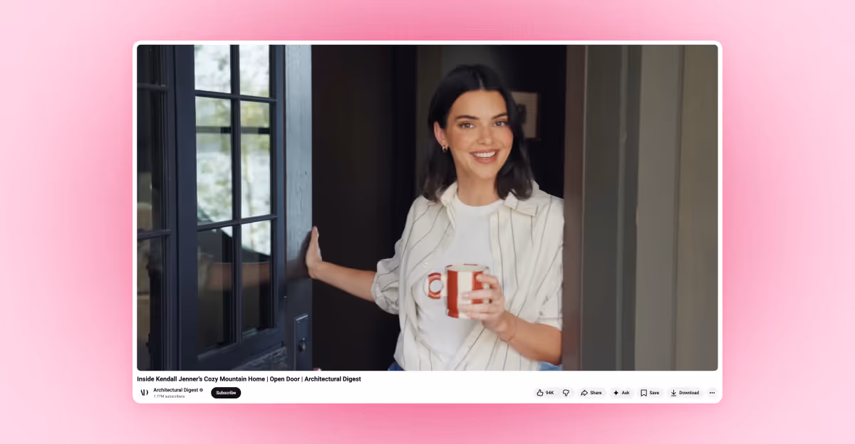 Smiling Kendall Jenner holding a striped mug while standing in a doorway.