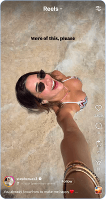 Woman in sunglasses relaxing on sandy beach taking selfie in sunlight