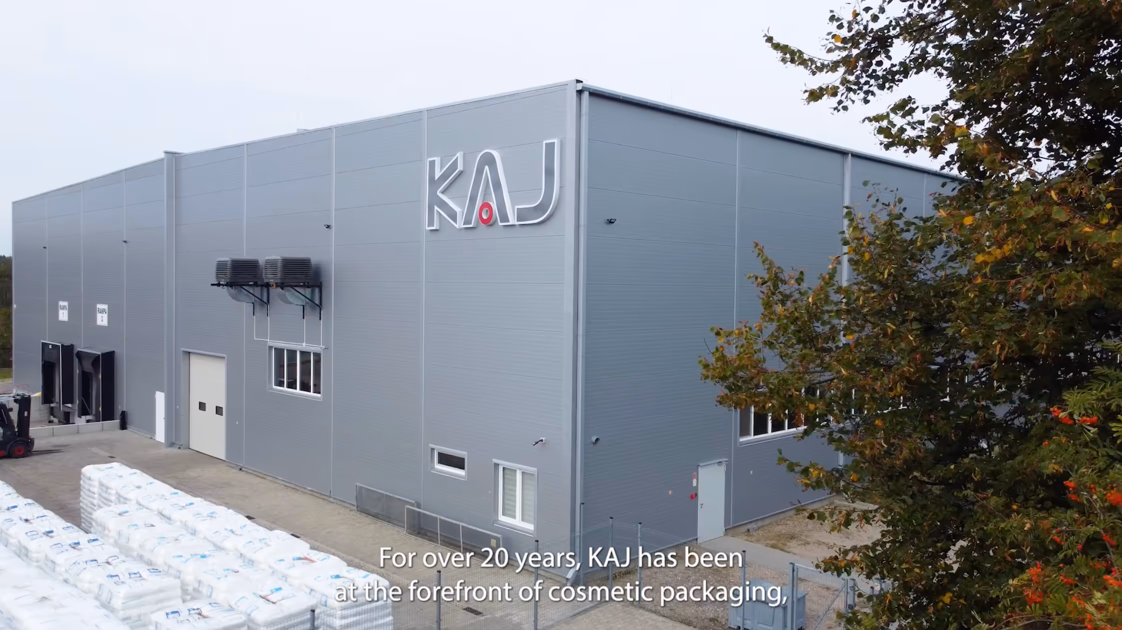 “KAJ Packaging warehouse interior showing rows of shelving and packaging materials”