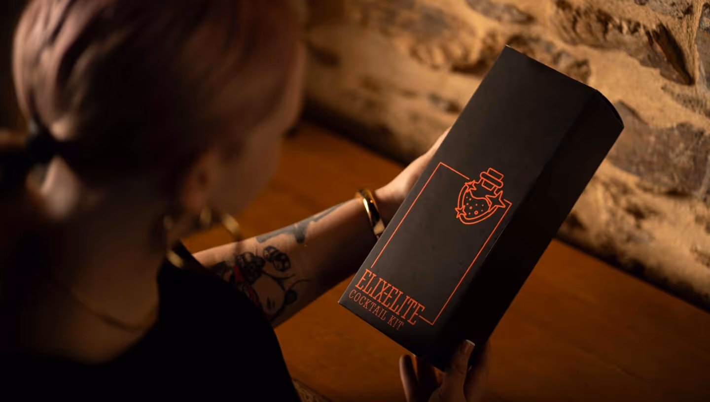 A woman holding a box with the word Elix-Elite on it.