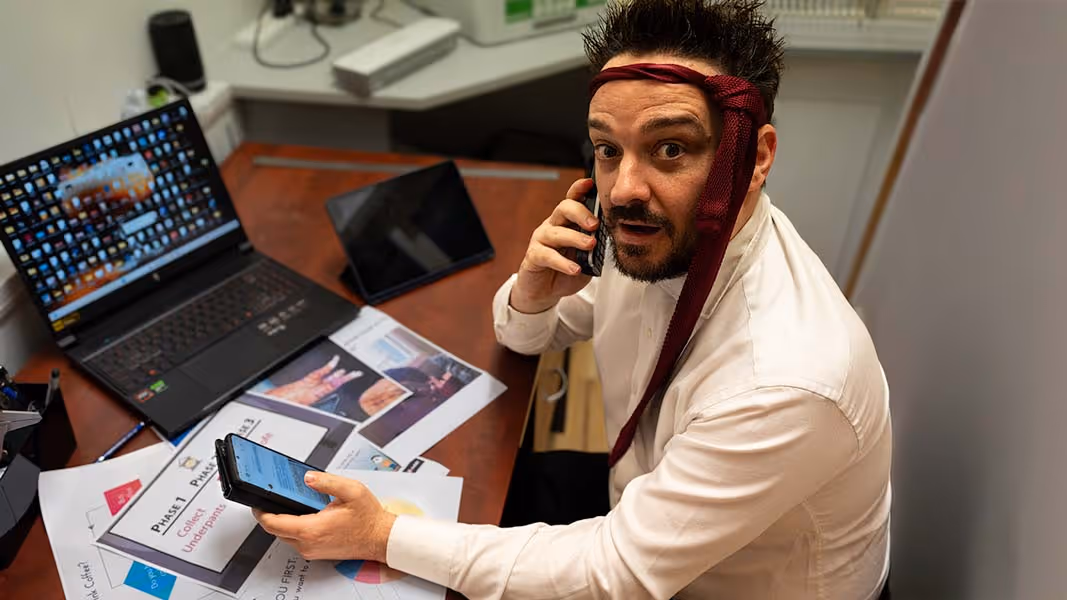 A man wearing a red bandana and white shirt talking on a cell phone.