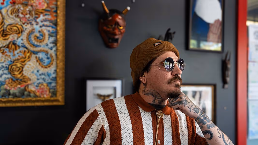 A man with a brown hat and a striped shirt.