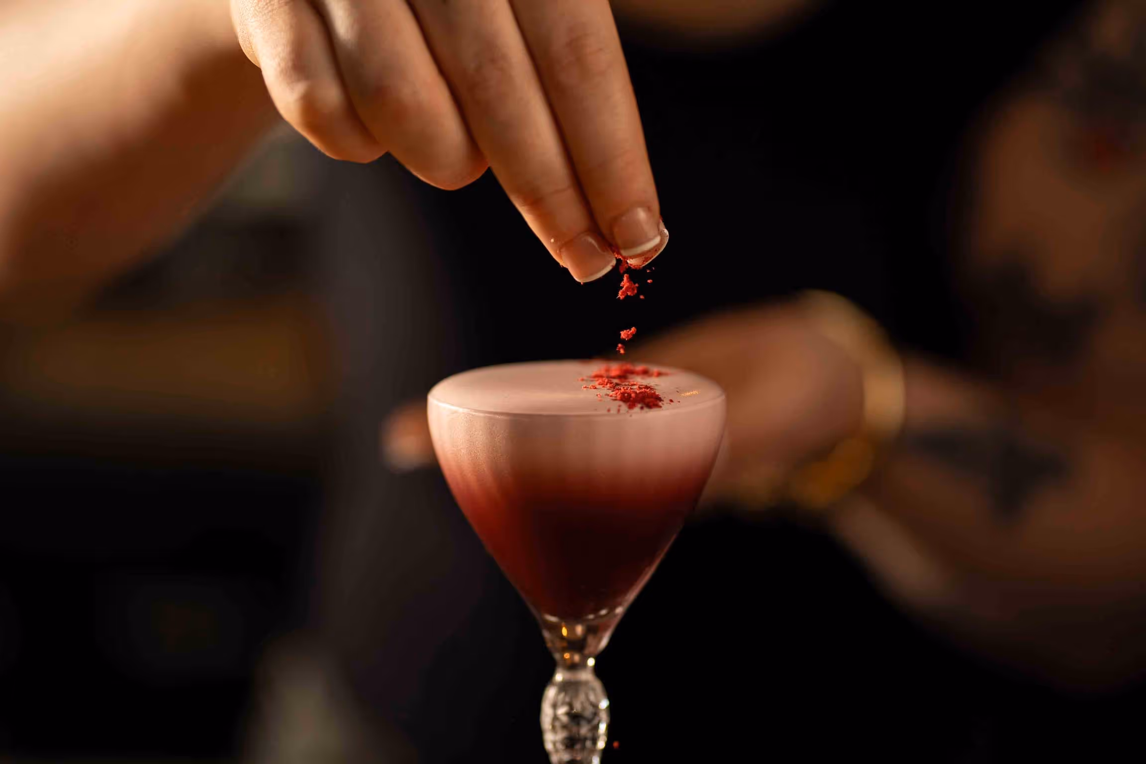 A woman pouring a drink into a glass.