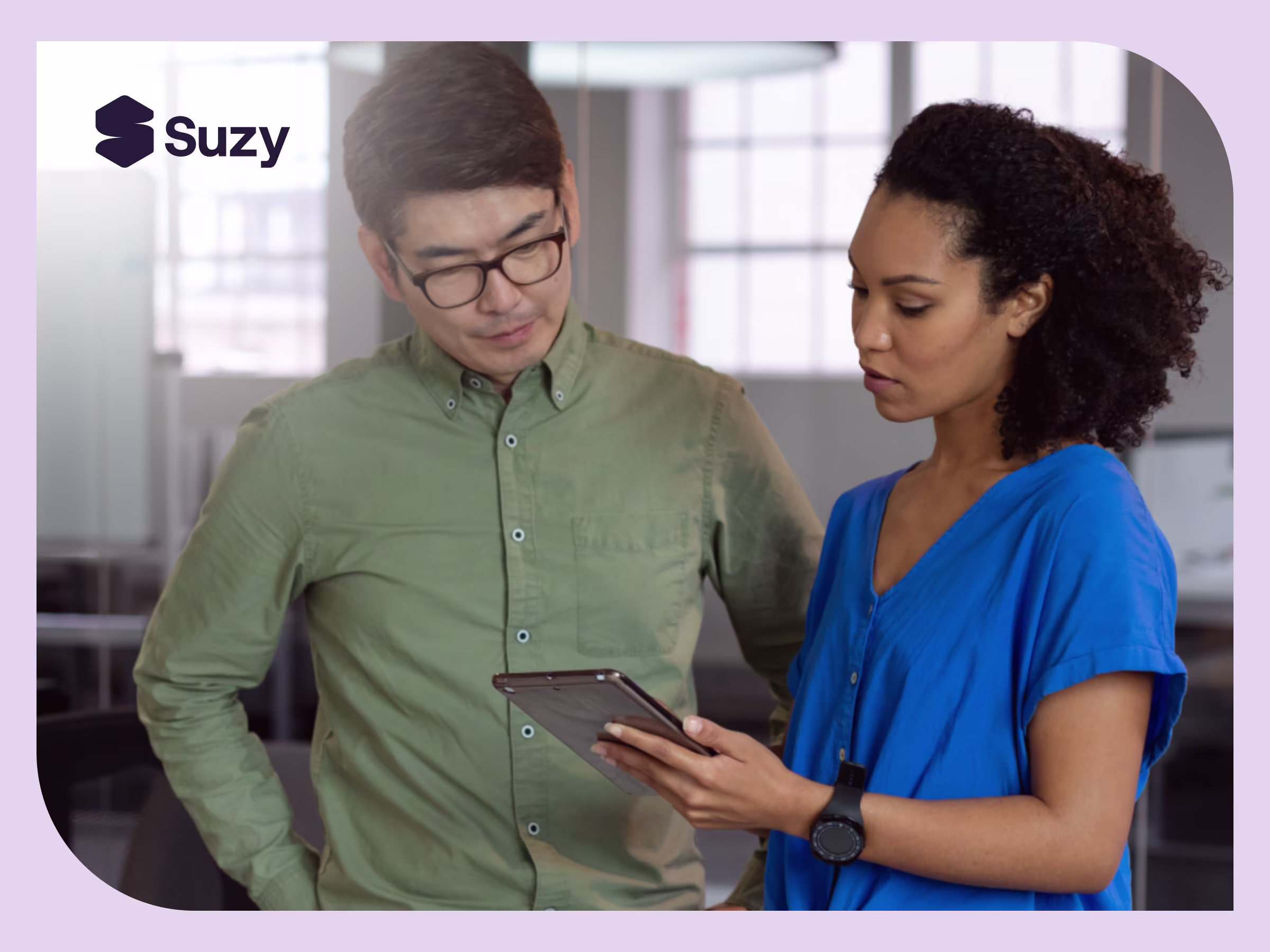 Two colleagues reviewing insights on a tablet in a modern office, representing Suzy’s consumer insights platform