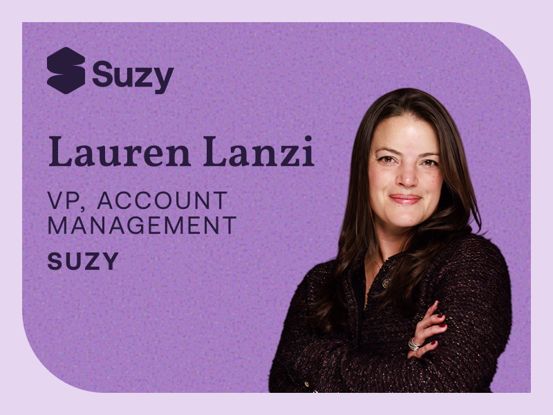 Promotional blog header image with a purple background featuring a smiling woman with long dark brown hair, wearing a dark top with arms crossed. Text overlay reads: "Suzy" logo (top left), "Lauren Lanzi, VP, Account Management, Suzy."