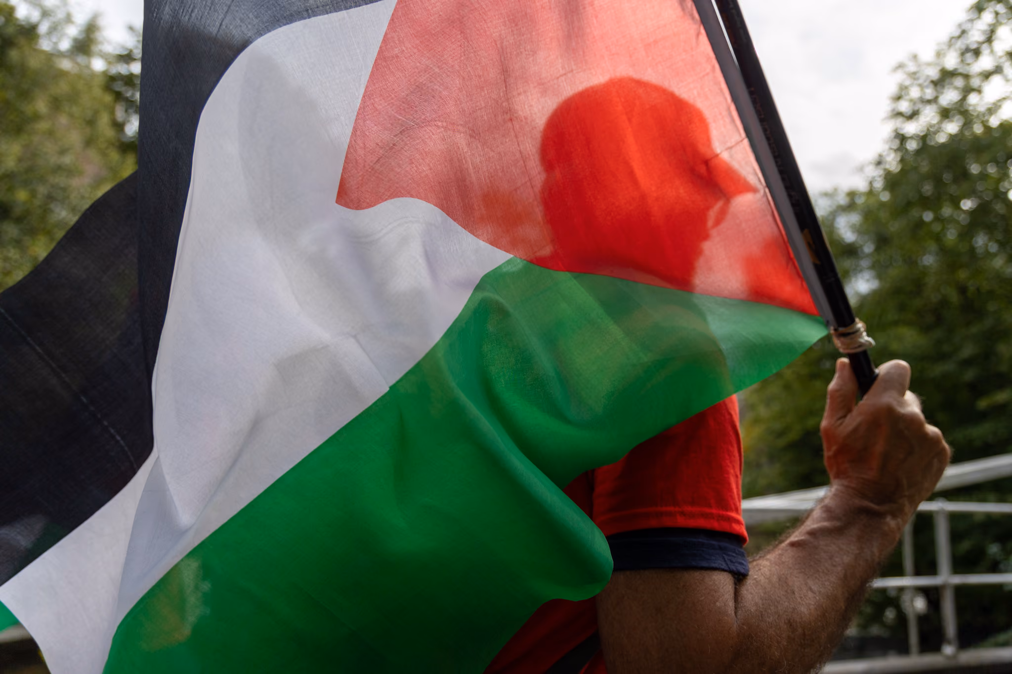 Mann holder Palestina-flagg mens han løper